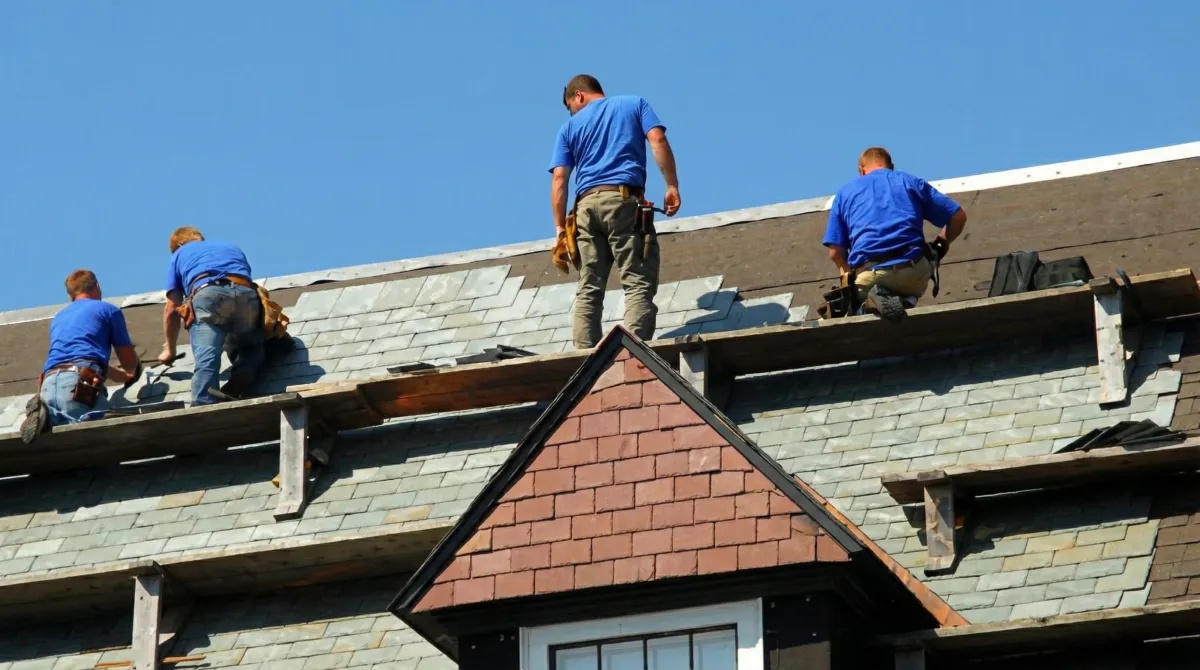 Roof replacement in progress with a team of professional contractors installing new shingles on a residential home in Manchester, NH